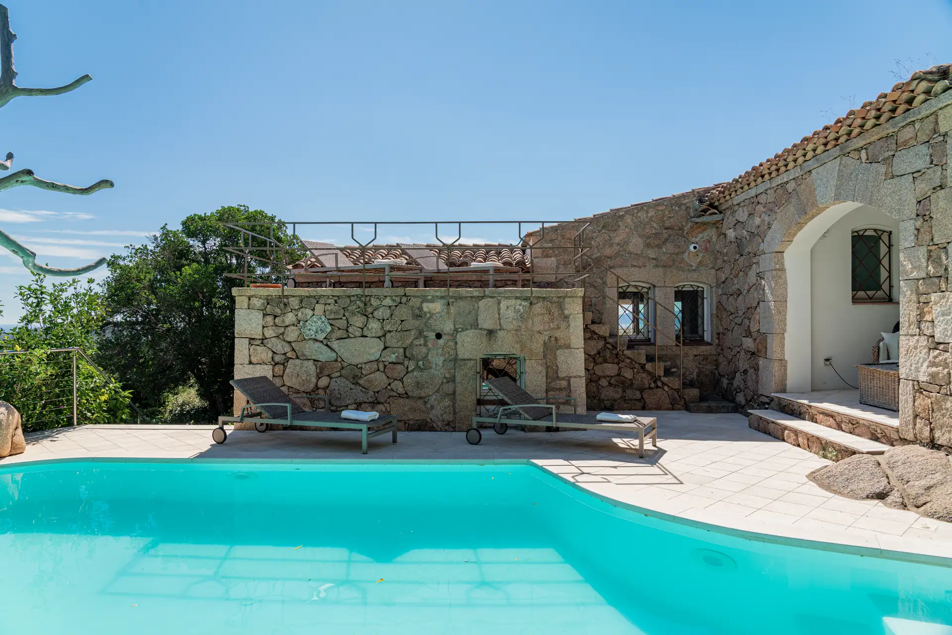 Piscina con muro granito e terrazza solarium
