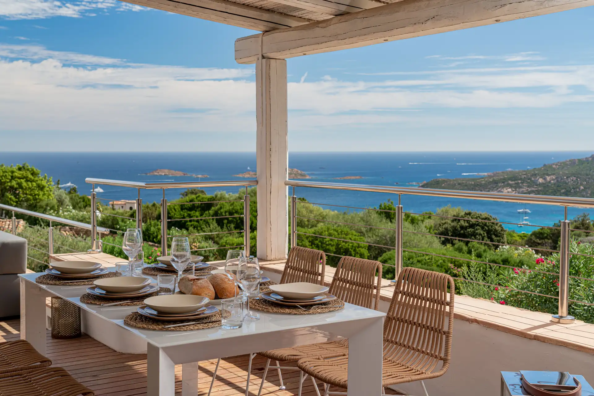 Tavolo bianco con sedie rattan, vista mare